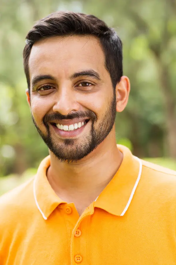 young-indian-man-happy-outdoors-looking-camera-39595562